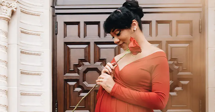 black woman in red dress for maternity photoshoot