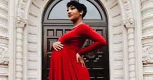 black woman in red dress for maternity photoshoot