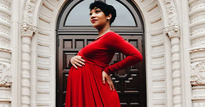 black woman in red dress for maternity photoshoot